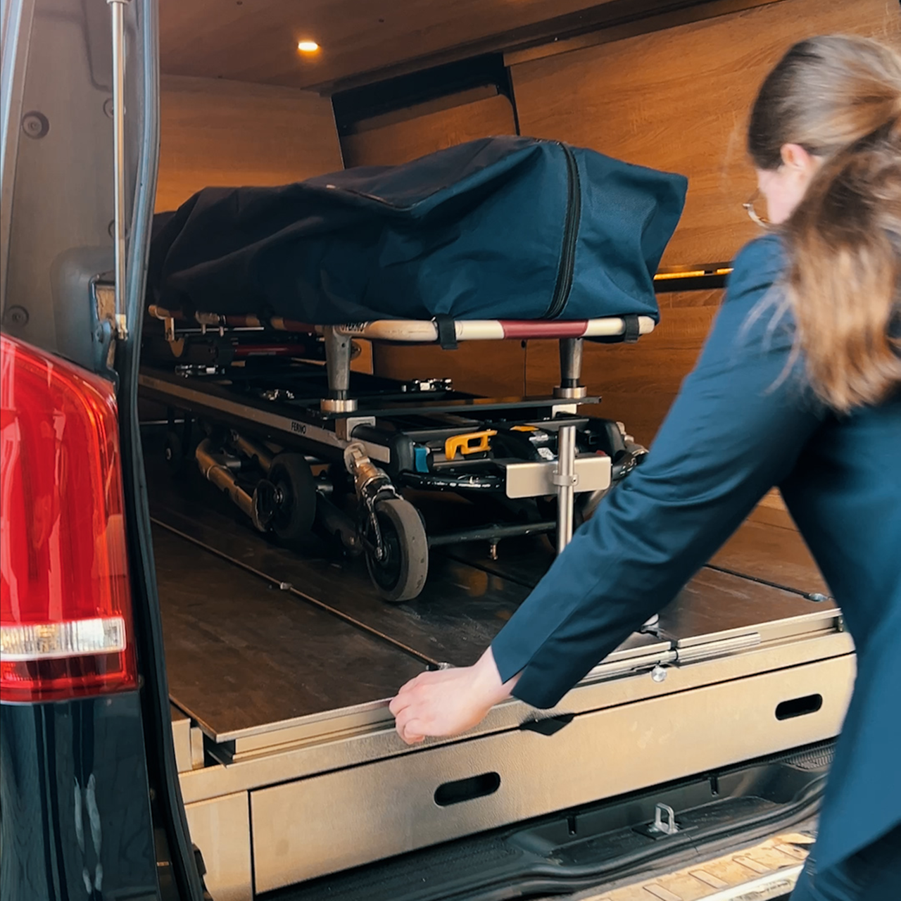 Frau zieht Leichensack aus Auto