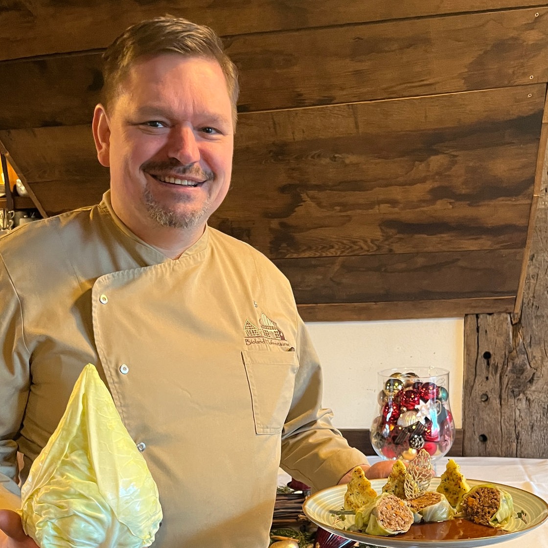 Dirk vom Bioland-Hofrestaurant in Syke mit einem Teller Essen