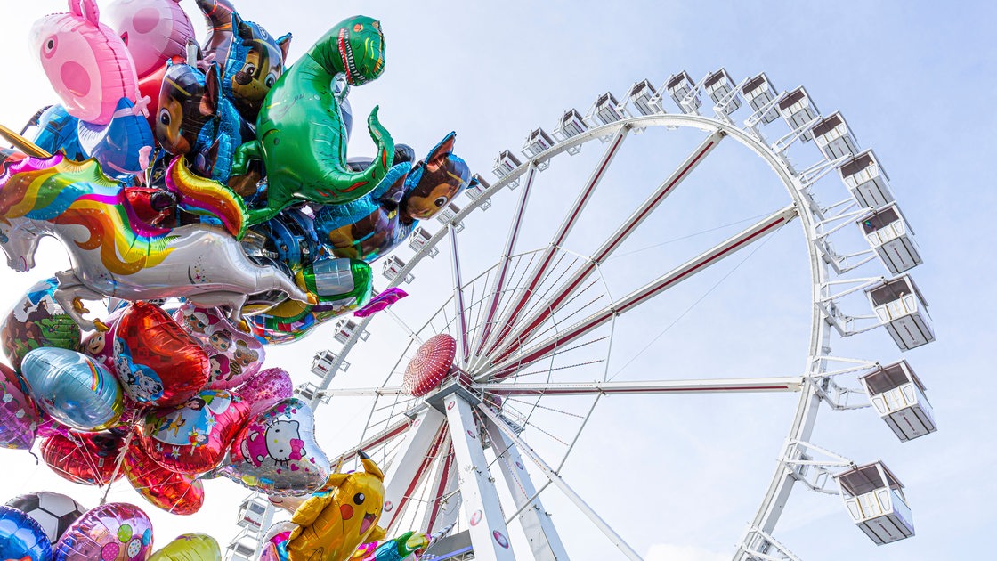 Heliumballons für Kinder und ein Riesenrad im Jahr 2019 auf dem Bremer Freimarkt. 
