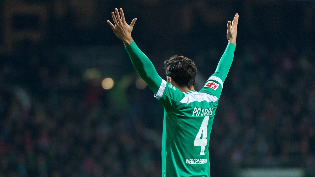 Claudio Pizarro von hinten im Werder-Trikot fotografiert, wie er die Hände Richtung Tribüne hochreißt und feiert.