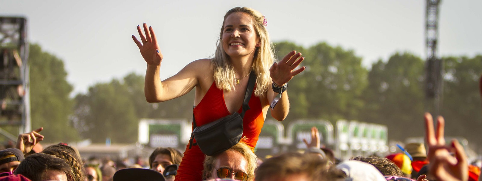 Eine Frau tanzt auf den Schultern einer anderen Person beim Hurricane-Festival