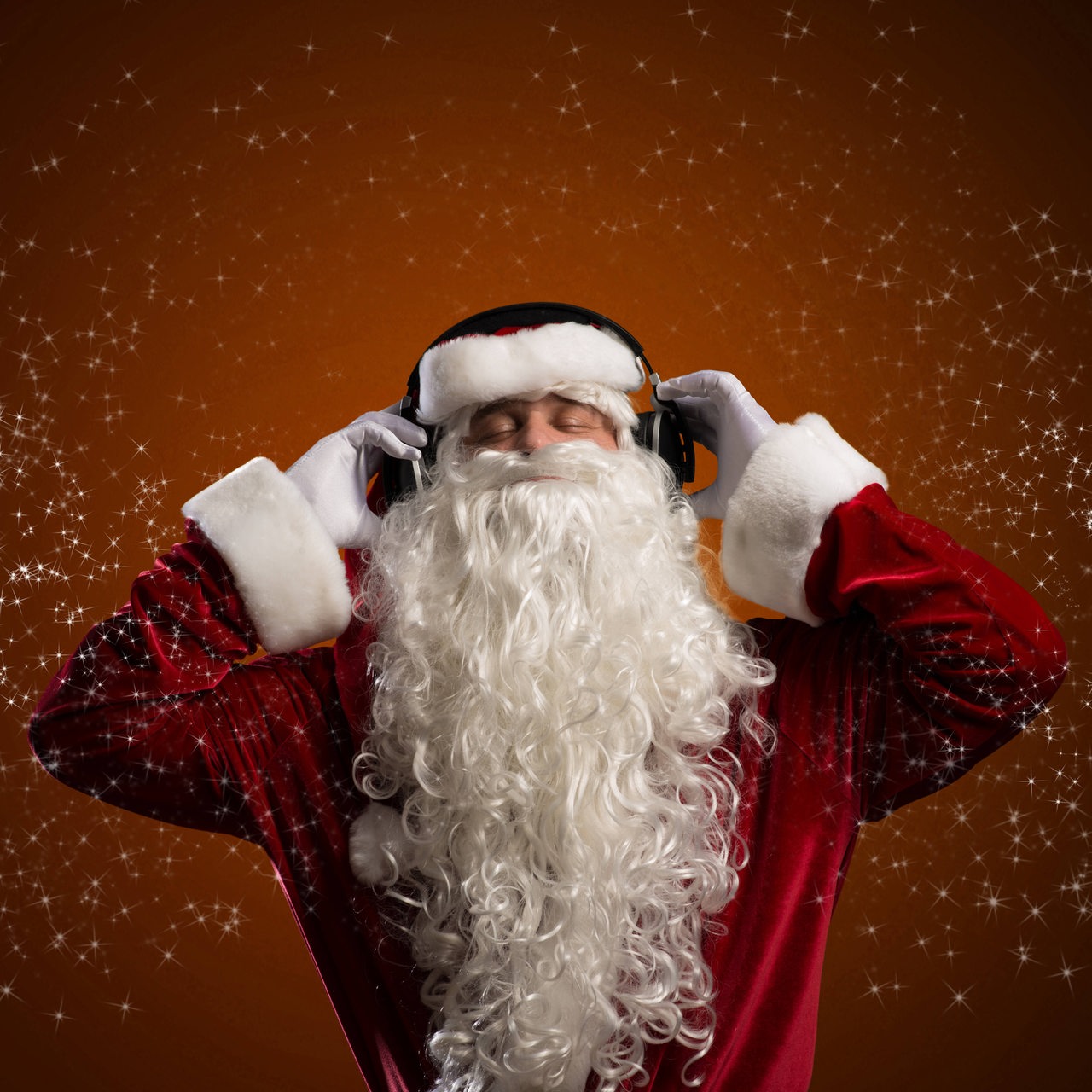 Ein Weihnachtsmann hört Musik über Kopfhörer.