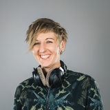 Moderatorin Julia Bamberg mit Kopfhörern um den Hals in einem dunkelgrünen Hemd