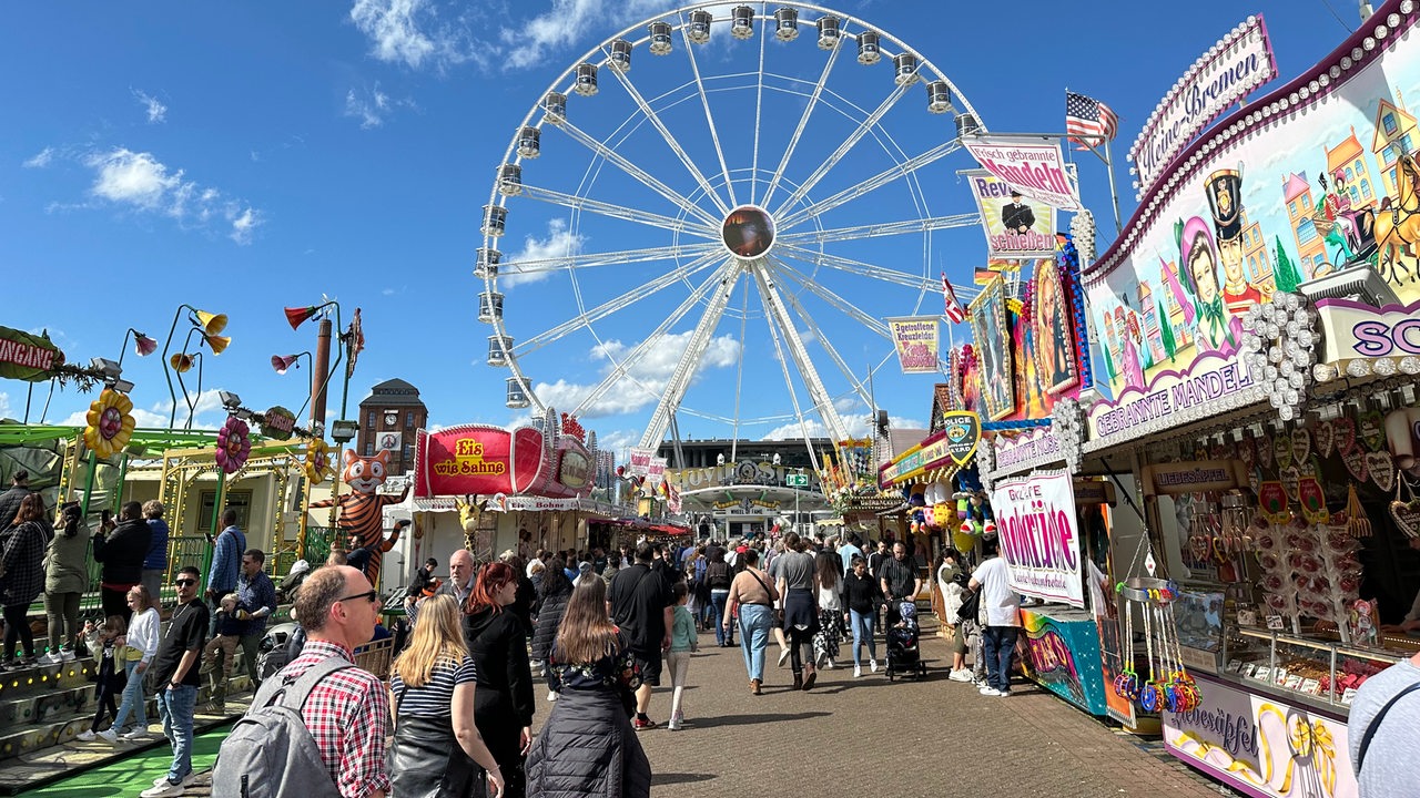 Menschen laufen auf der Osterwiese, im Hintergrund ein Riesenrad