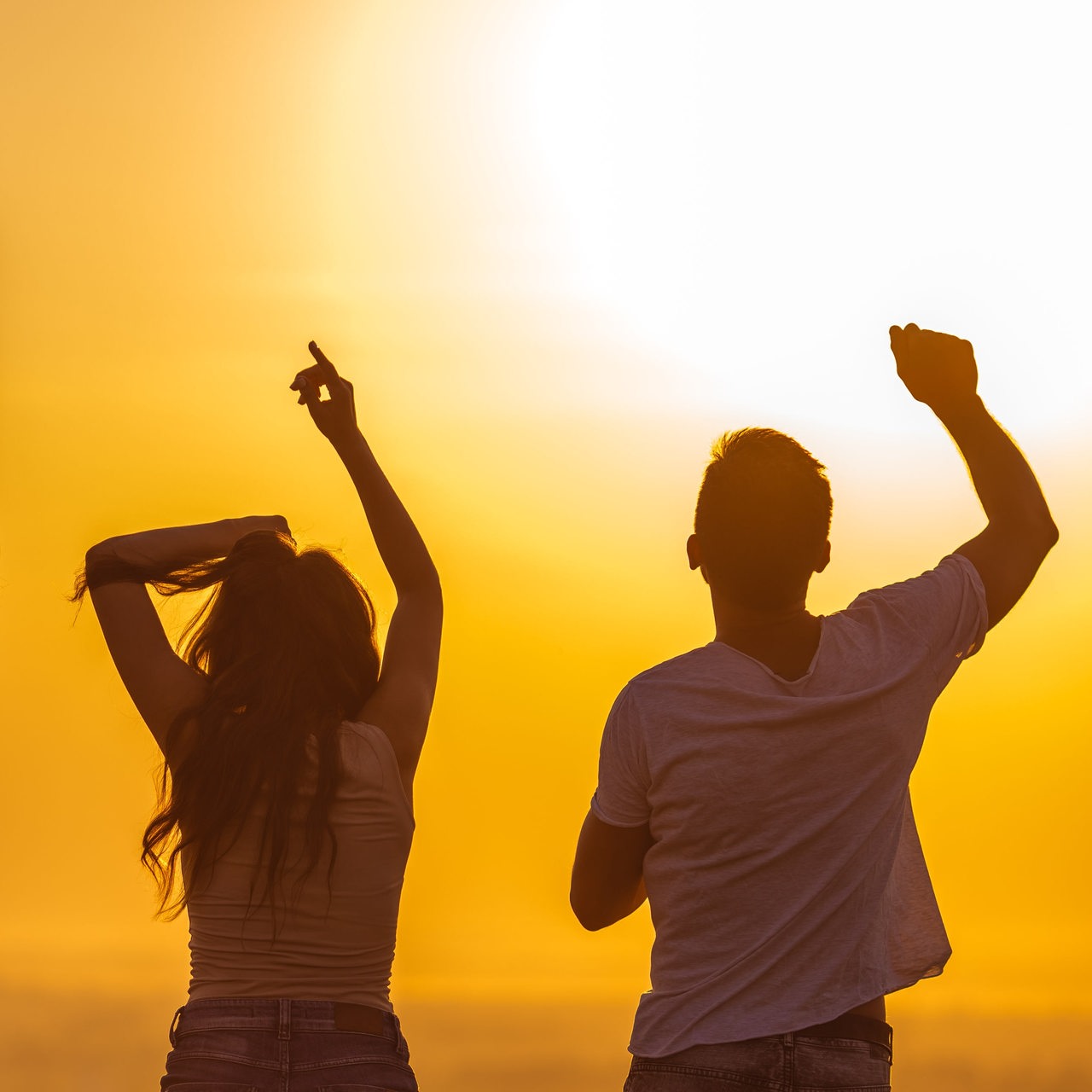 tanzende Menschen vor Sonnenuntergang