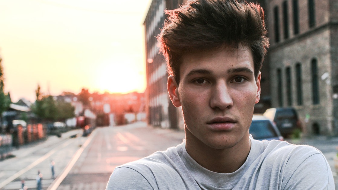 Sänger Wincent Weiss. Sonnenuntergang und Straße im Hintergrund.