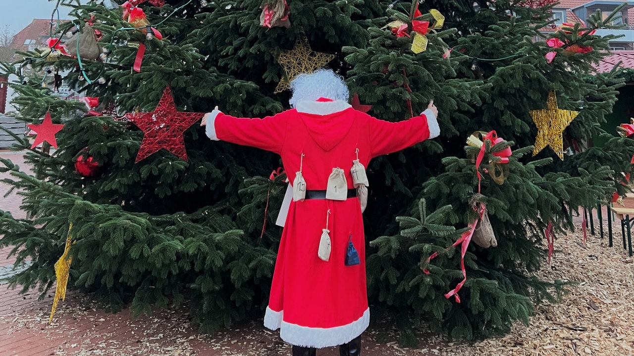 Weihnachtsmann mit Adventskalenderpäckchen behangen